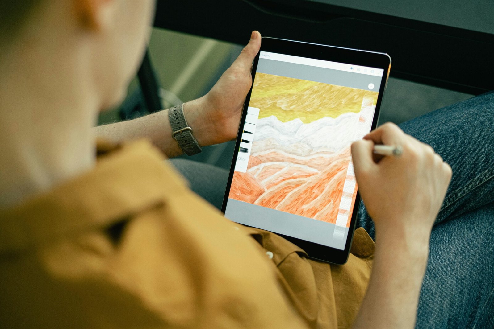 person drawing a scenery on ipad