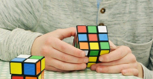 Person solving a 2x2 Rubik's Cube, focusing on techniques to solve it efficiently.