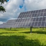 Solar panels in a field under a cloudy sky, highlighting issues on AppraisersForum for homeowners unable to prove solar is permitted