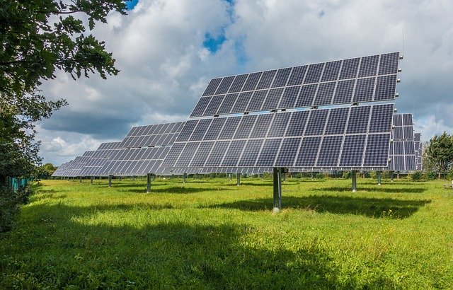 Solar panels in a field under a cloudy sky, highlighting issues on AppraisersForum for homeowners unable to prove solar is permitted